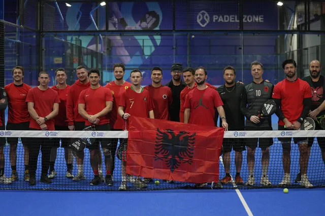 Players in red shirts holding the Albanian flag on court at the Flag Day Americano