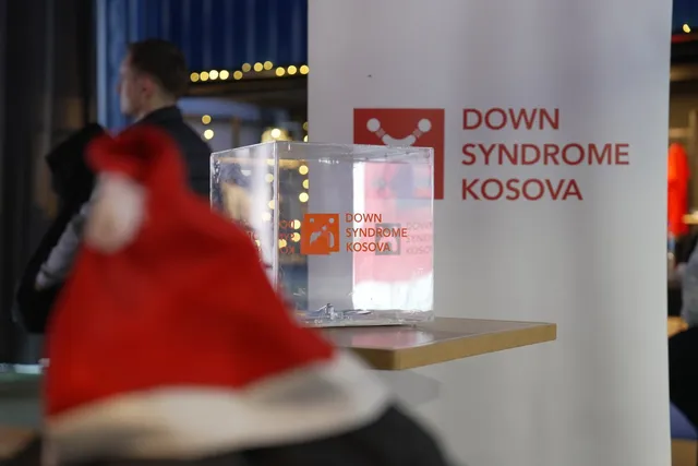 Santa hat and donation box next to the Down Syndrome Kosova banner at the Christmas tournament