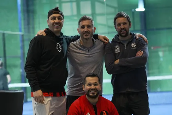 Four friends with their arms around each other on court after a match