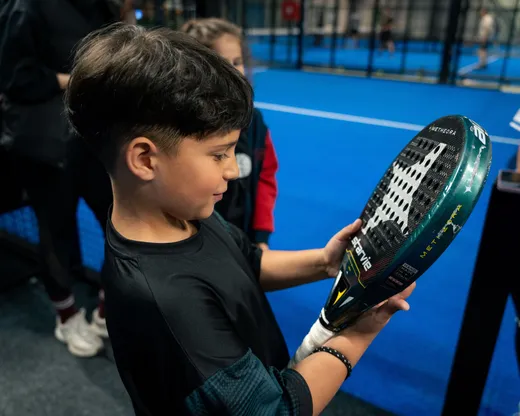 A young academy player holding his racket up, ready for the next ball